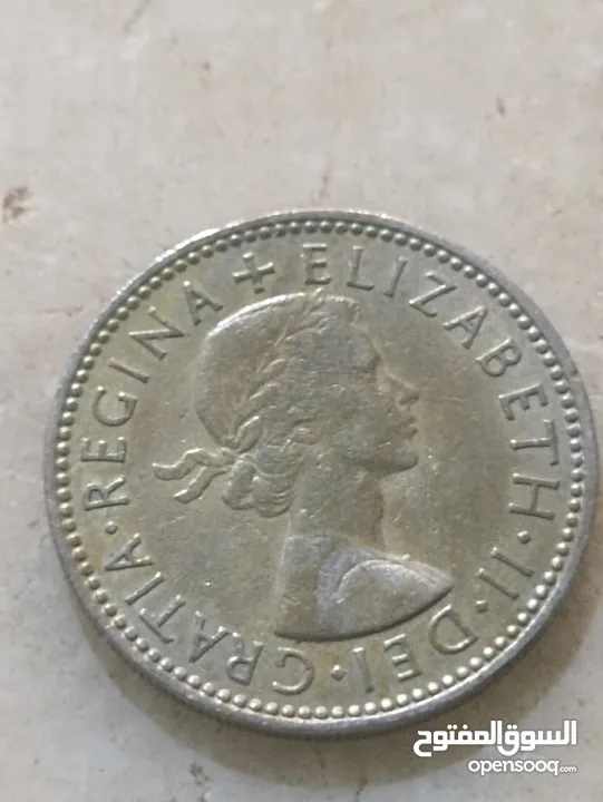 تُظهر الصورة عملة شلن بريطانية تعود لعام 1958.   كان الشلن البريطاني، الذي يُختصر بـ "1s" أو "1/-"،