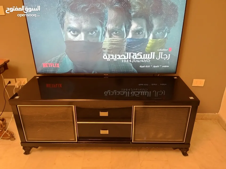 طاولة تلفزيون لون اسون بحالة ممتازة للبيع درجين وسطانيات واماكن تخزين جانبية  سطح زجاجي وارفف زجاجية