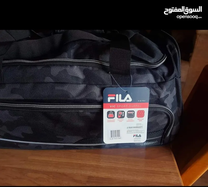 شنتة ماركة FILA اصلية جديدة صناعة كمبوديا للسفر او الجيم مع جيبة خارجية لون جيشي