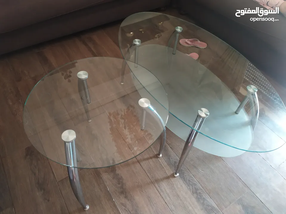 طاولة زجاج وكراسي خشب ولوحات