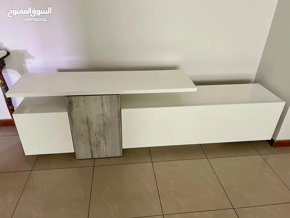 طاولة تلفزيون لامنيت لون ابيض بحالة الجديد مع وحدات تخزين