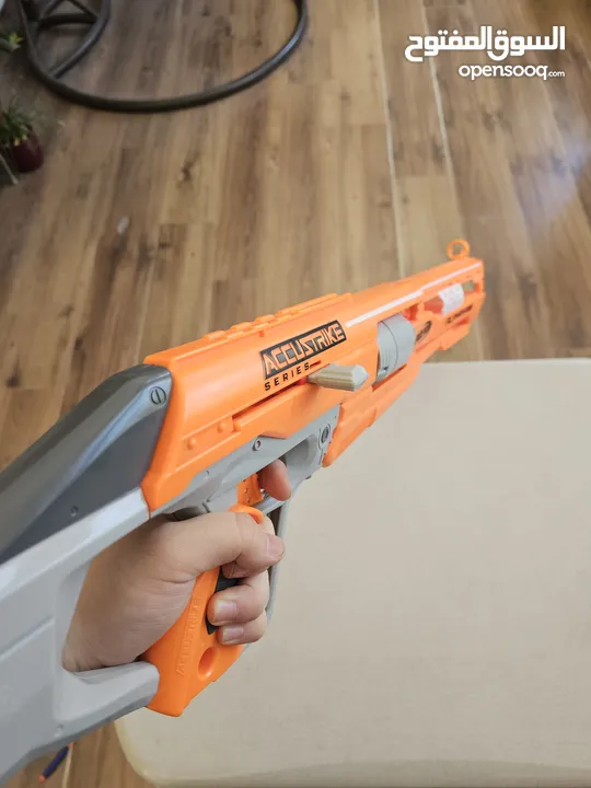 accustrike toy blaster with 5 bullets, 4 similar and 1 diffent