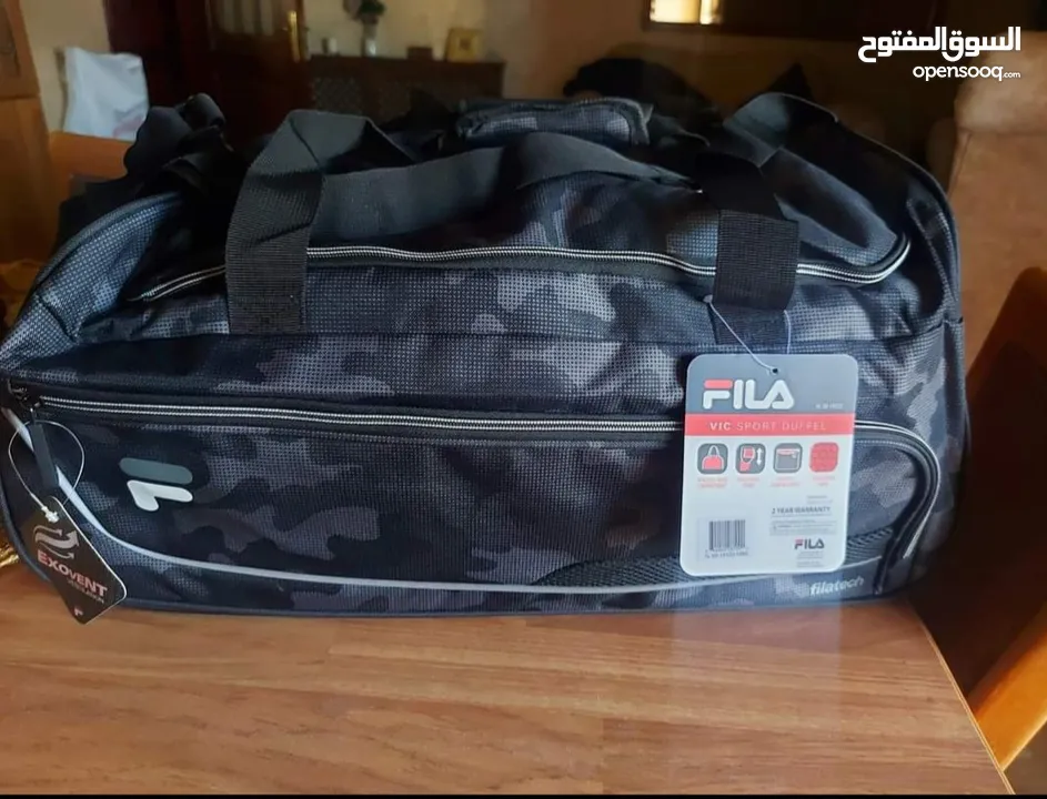 شنتة ماركة FILA اصلية جديدة صناعة كمبوديا للسفر او الجيم مع جيبة خارجية لون جيشي