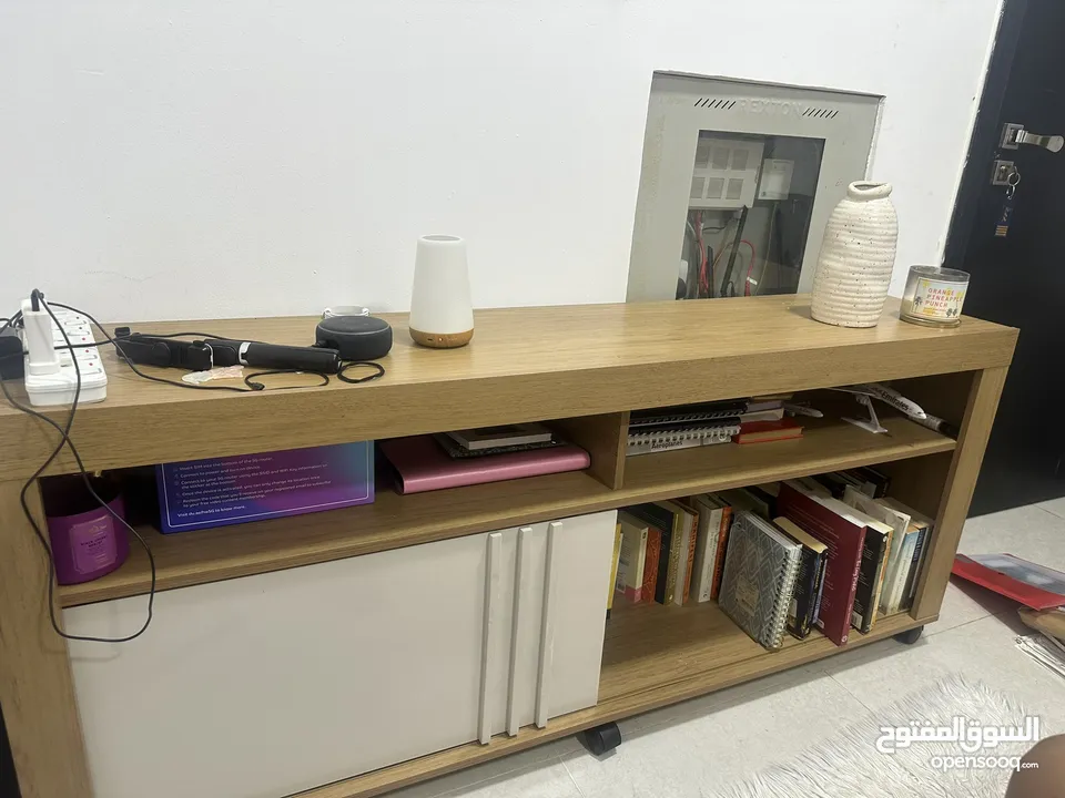 A fairly used tv stand with book shelves,