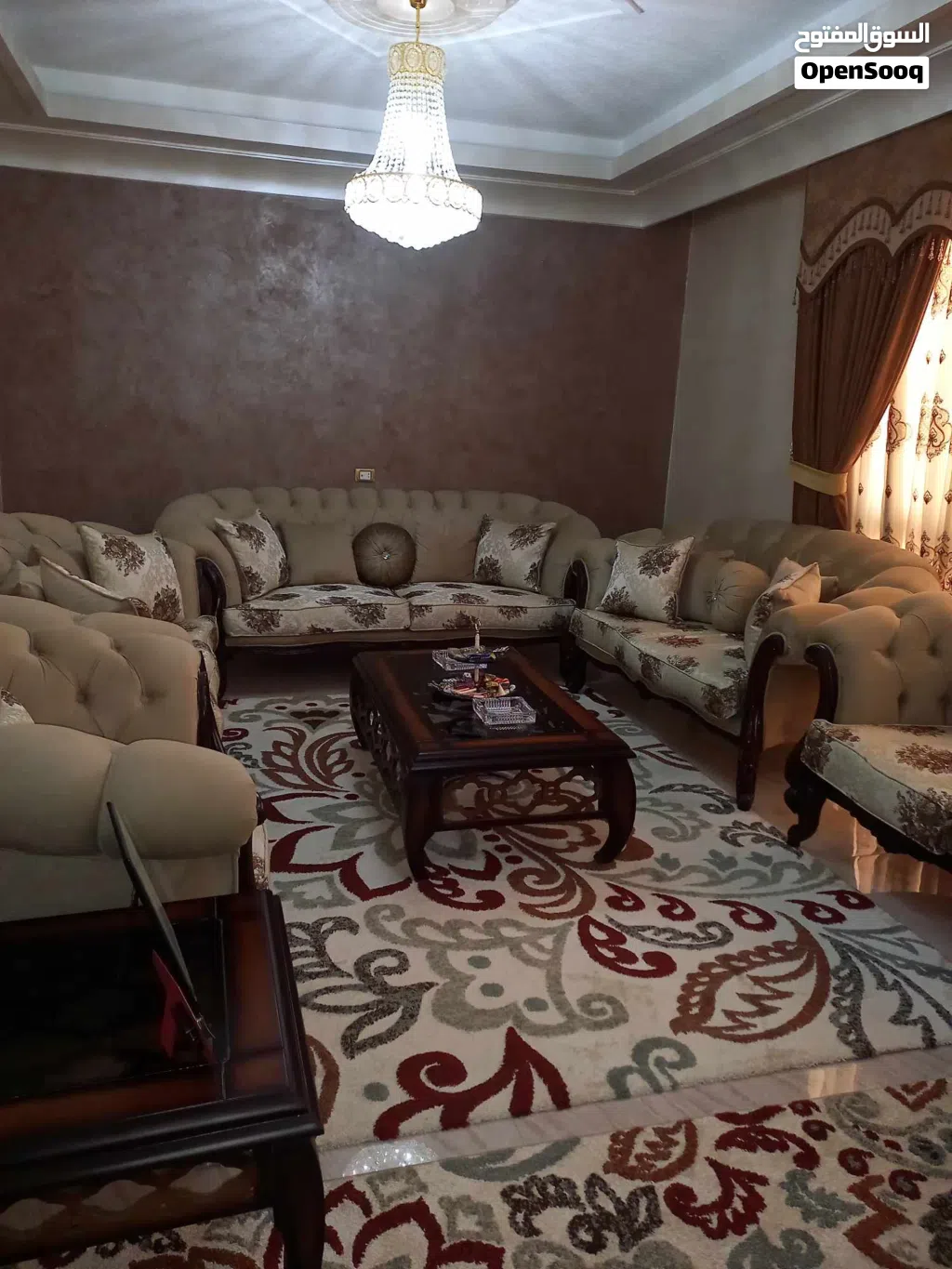 طقم كنب لون بيج مع بردايه وطاوله وسط واثنتين جانبيات