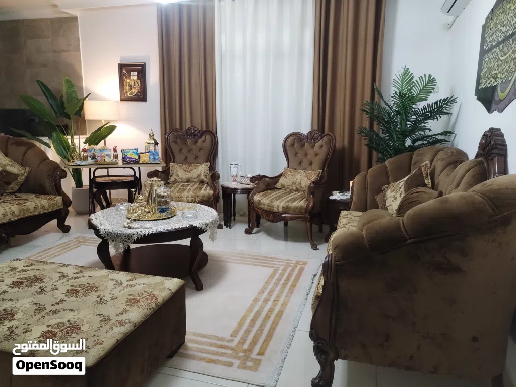 طقم كنب سبع مقاعد مع ثلاث طاولات زجاج والستاره