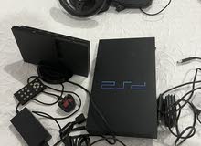 2 PlayStation 2s with guitar hero, sing star and driving wheel