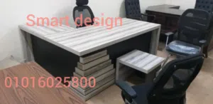 مكتب مدير بتصميم عصري من الخشب الرمادي يتميز بنقوش هندسية مذهبة، يشمل مكتباً رئيسياً مع طاولة ضيافة