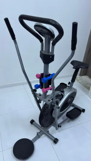 هذا جهاز إليبتكال (Elliptical Cross Trainer) مع مقعد، ومعه دمبل خفيفة
