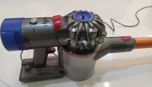 تُظهر الصورة مكنسة Dyson V8 اللاسلكية، وهي مكنسة كهربائية مشهورة بقدرتها على التنظيف العميق