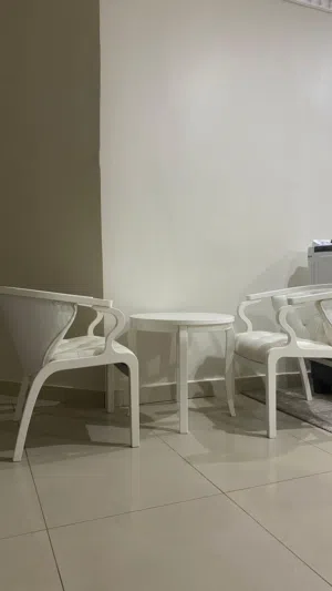 طاولة بيضاء مع كرسيين مريحين