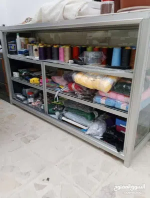 ماكينة خياطه درزه وبترينا زجاج مع رفوف لمخيطه بحاله ممتازه جدا