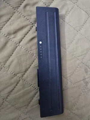 بطارية وشاحنة لابتوب dell القطع الظاهرة في الصور هي بطارية بديلة وشاحن أصلي، وكلاهما مخصصان للابتوب