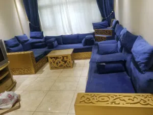 مجلس ازرق مسخدم نظيف جدآ مع طاوله ذهبية وزاويه ذهبية ايضآ وستائر زرق كبيره الحجم تنفع لاي مكان