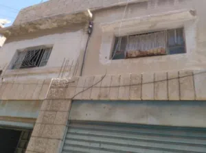 فرصة استثمارية في الزرقاء: أرض + 4 مخازن و3 شقق مجاناً!