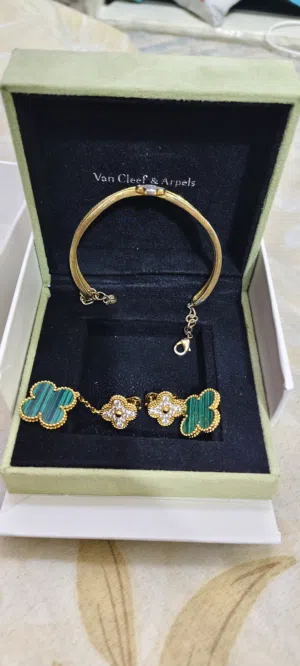 Van Cleef & Arpels bangle & Magic Alhambra earrings features a delicate yellow gold band punctuated