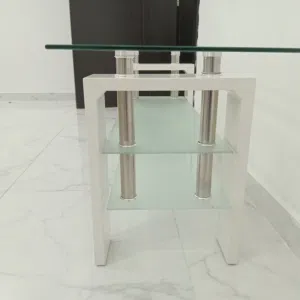 طاولة القهوة المعروضة هي طاولة قهوة مستطيلة حديثة بسطح زجاجي شفاف وأرجل بيضاء سميكة. تتميز بتصميم يو