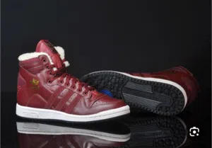 حذاء Adidas Originals Decade OG Mid باللون الأحمر الماروني مع تفاصيل ذهبية وبطانة داخلية من الفرو ال