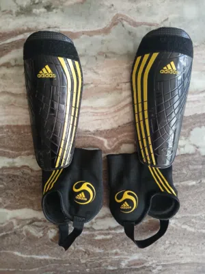 كسارات حماية لكرة القدم من نوع Adidas موديل F50 لون اسود و اصفر تصميم عصري و جميل قويه جدا حمايه