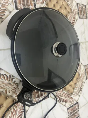 طاوة كهربائيةحرارته عالية تيڤال معها قبغ زجاج ثقيل محكم مستعملةوليست جديدة وما بيه كارتون ماكو توصيل