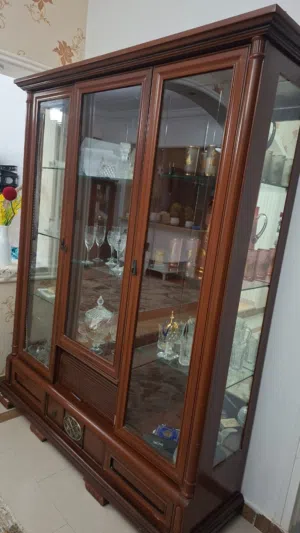 طاولة مدورة حجم كبير وبوفي تلات فرادي فيه قجورا تحت والبوفي الاخر فردة وحده فقط وفيه قجر من تحت ل