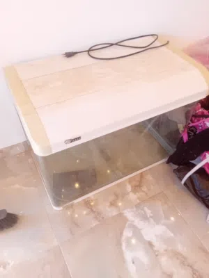 حوض سمك كبير فيه إضاءة وفيه شق من الجنب فيه شوية تسريب يبي سيليكون