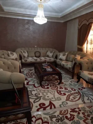طقم كنب لون بيج مع بردايه وطاوله وسط واثنتين جانبيات