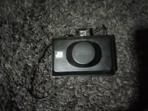 كاميرا Polaroid EE100، وهي كاميرا فورية قديمة (Vintage) تتميز بتصميم "المنفاخ" القابل للطي.