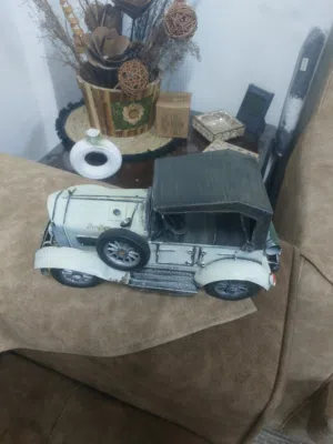 تحفة معدنية على شكل سيارة كلاسيكية عتيقة (Vintage)، تُستخدم غالبًا للديكور المنزلي أو المكتبي.