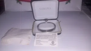 سوار Sabona للجنسين يتميز بتصميم بسيط مع مشبك تقليدي. معاه العلبة بتعتة و الكتالوج أو البطاقه التعري