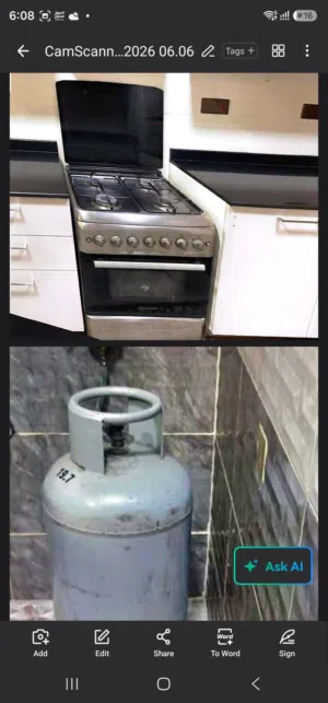 4-burner gas stove with an oven and a gas cylinder.