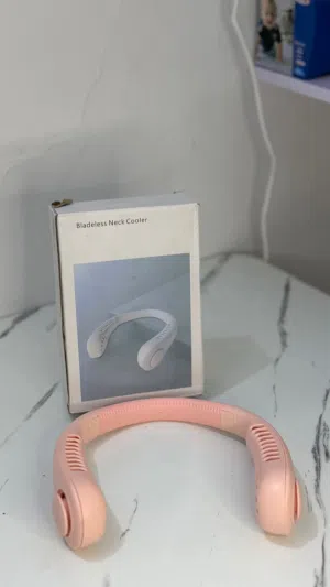 هذا المنتج عبارة عن مروحة رقبة قابلة للشحن (Bladeless Neck Cooler)، وتتوفر باللون الوردي