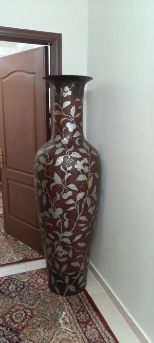 مزهرية ديكور كبيرة وفخمة جداً، تصميم أنيق بلون بني غامق مع نقوش وزخارف نباتية بارزة بلون ذهبي/فضي .
