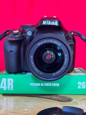 كاميرا نيكون Nikon D5200  مع عدسة 24 إلى 55ملم وشنطة وشاحن نيكون  وبطارتين ستراب نيكون الأصلي.