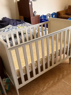 White wooden baby crib with matress