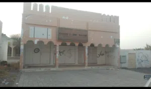 ارض سكني تجاري بها محلات بالبريمي