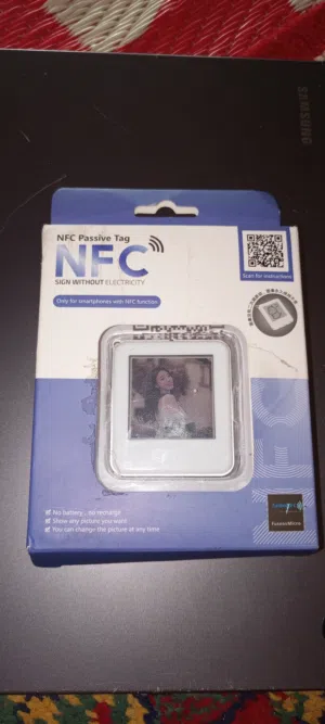 هذه القطعة في الصورة تُسمّى NFC Passive Tag (بطاقة/ملصق NFC بدون بطارية)، وهي جهاز صغير ذكي