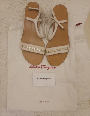 للبيع صندل نسائي فاخر من Salvatore Ferragamo باللون الأوف وايت مع تفاصيل معدنية أنيقه
