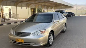 تويوتا كامري 2004 موديل LE ذهبي مع مواصفات أمريكية، سجل مرخص وبيانات تقنية مميزة