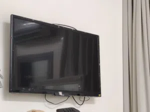 شاشه مع جهاز شاومي مي بوكس إس (الجيل الثالث) المخصص لتحويل التلفزيونات العادية إلى أجهزة ذكية.