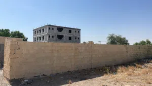 ارض سكني تجاري للبيع شبة زاويةمسورة بجدار وبها غرفتين وماجرة