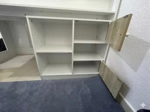 white bed with stairs,cabinets,and shelves
