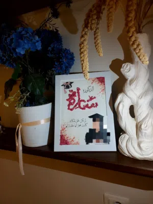 لوحه عليها الاسم والصوره مصنوعه من الورود الصغيره