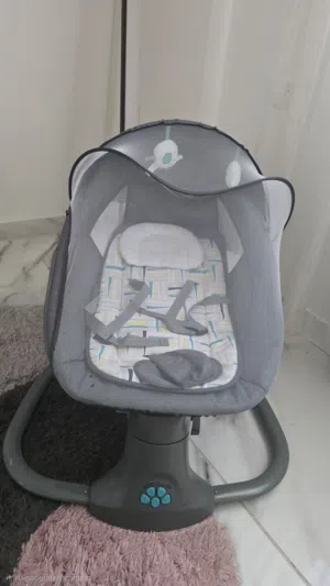 كرسي هزاز كهربائي للأطفال بحالة ممتازة - شبه جديد مع ناموسية وألعاب.