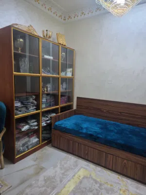كنب وسرير مع ادراج بان واحد خزانة عرض زجاج كبيرة جدا غرفة نوم