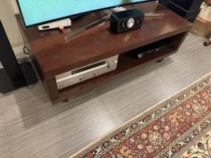 Sturdy wood TV stand with lockable wheels  حامل تلفزيون خشبي متين مزود بعجلات قابلة للقفل