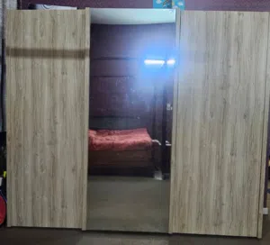 Bedroom cabinets and a bed with mattress with side tables of the bed and a dresser