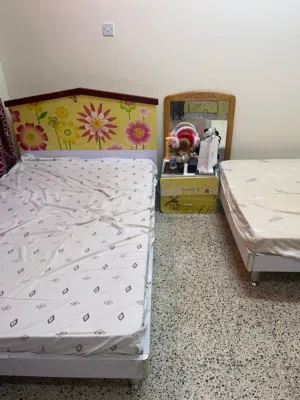 Two single beds with headboards and cabinet and bedside drawer
