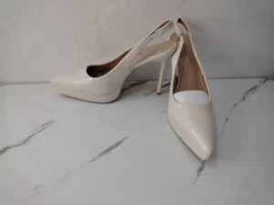 هذا الحذاء هو حذاء نسائي بكعب عالٍ ومقدمة مدببة وحزام خلفي، مشابه لموديلات "تشارلز آند كيث" بلون طبش