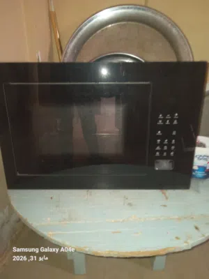 بناءً على الصورة، هذا الجهاز هو ميكروويف مدمج (Built-in) بباب زجاجي أسود بالكامل ولوحة تحكم رقمية